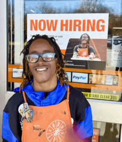 Bobby in front of The Home Depot's 'Now Hiring' poster